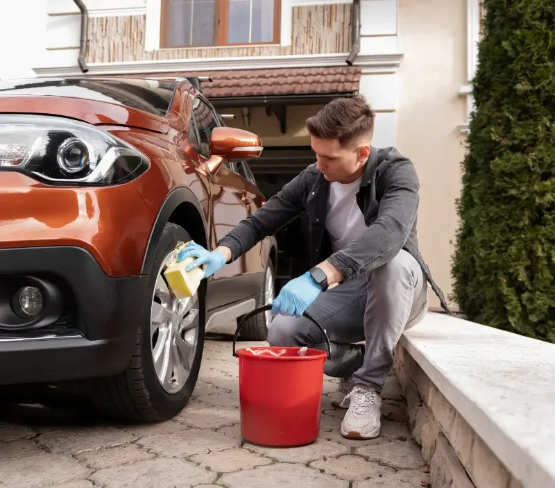 Lavage auto à domicile Le Plessis-Gassot : professionnel intervenant sur un véhicule